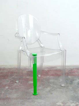 Przezroczyste, plastikowe krzesło z dosztukowaną zieloną nogą
